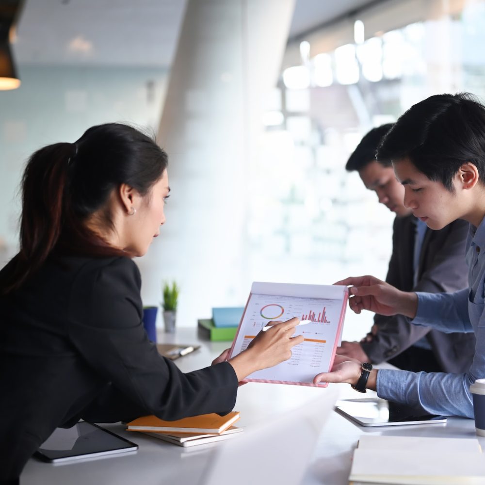 Business people analyzing documents and discussing business strategy at conference room.